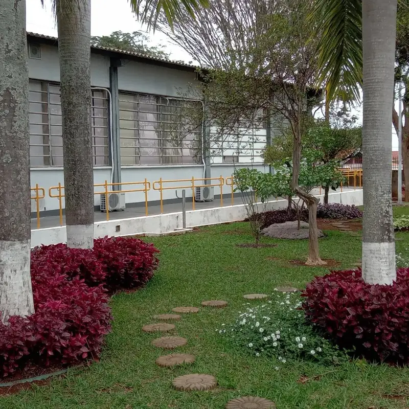Jardim corporativo nítido com gramado, árvores e canteiros ornamentais bem conservados