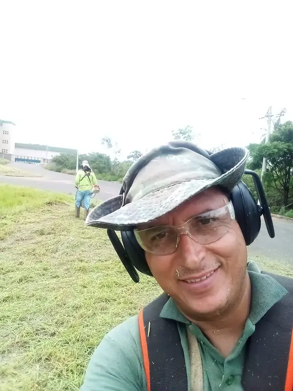 Equipe realizando manutenção de gramado em área verde
